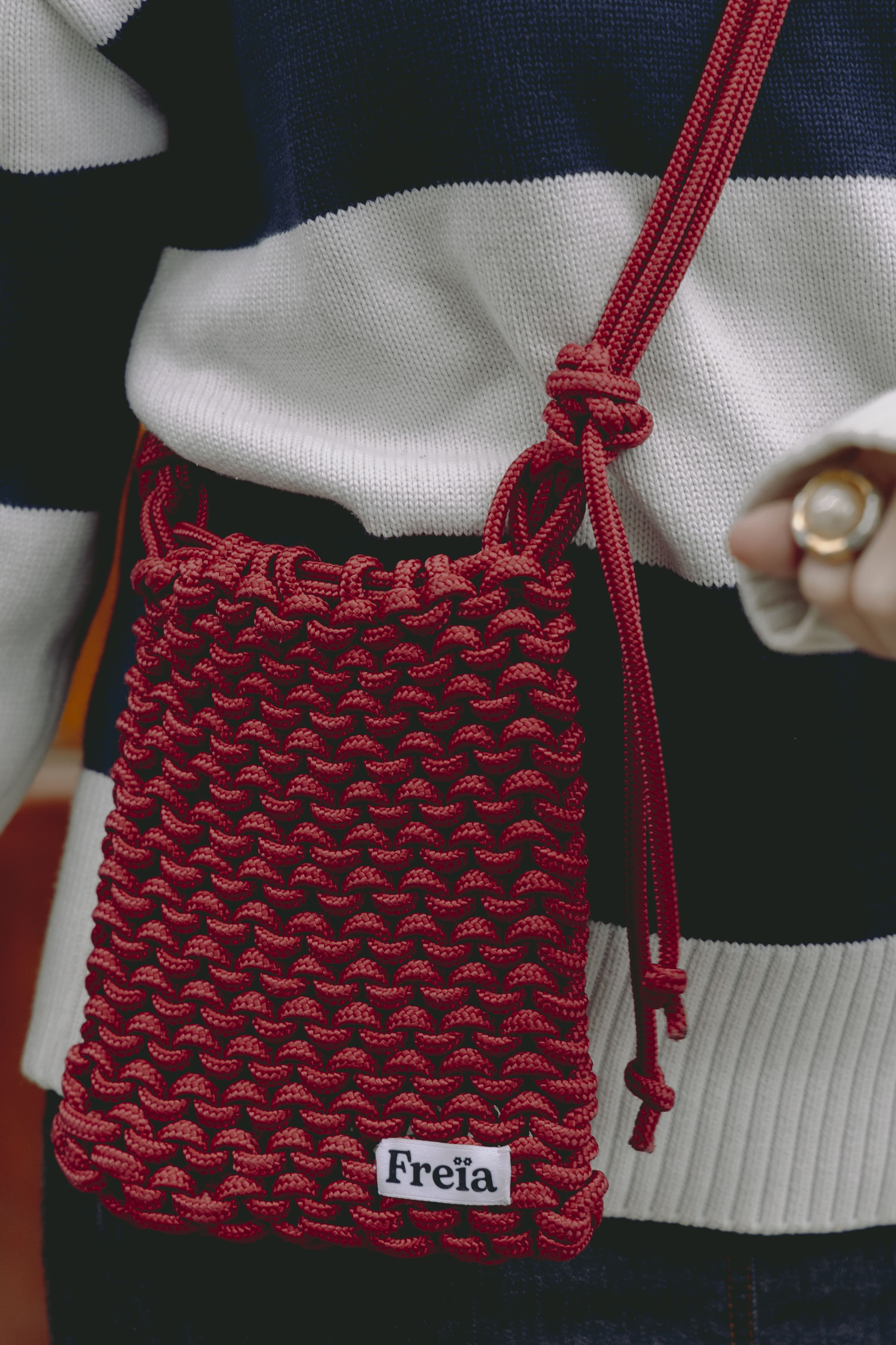 Gros plan d'un sac Freïa en paracorde rouge tressée à la main avec étiquette de marque