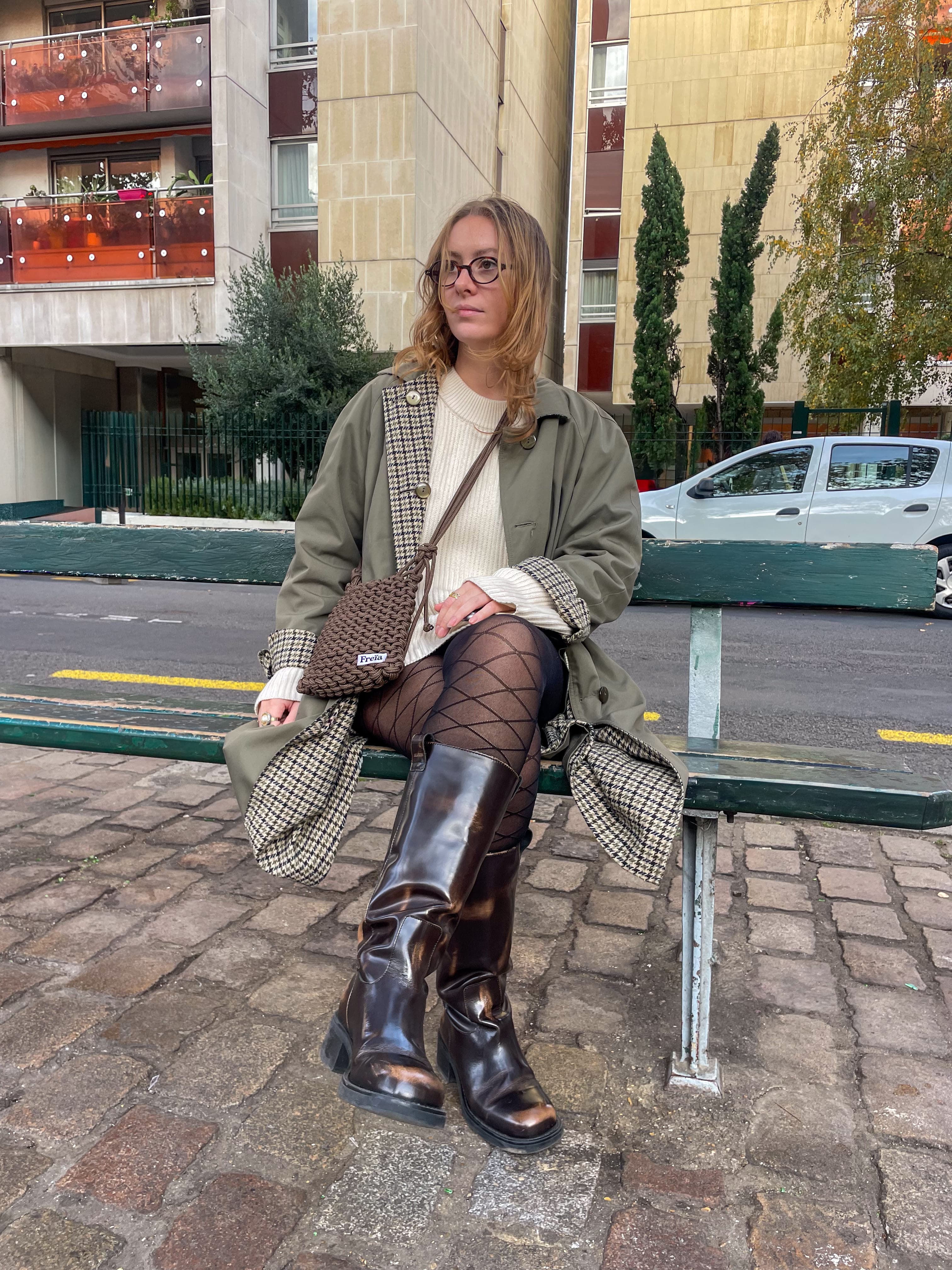 Femme assise sur un banc en ville avec un sac Freïa en paracorde marron à motifs